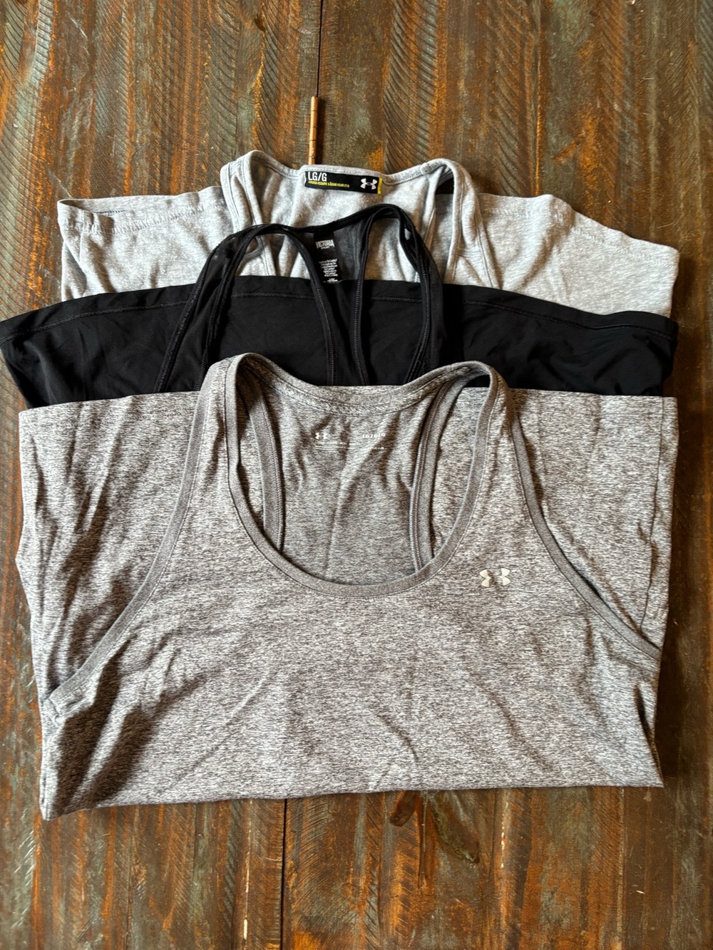 2 Under Armour Women’s Grey tank tops and 1 black Victoria Secret tank